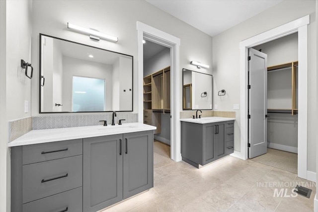 20042 N Swire Green Way Unit 459, Boise, ID 83714 - bathroom with two vanities, a spacious closet, tasteful backsplash, tile patterned floors, and baseboards
