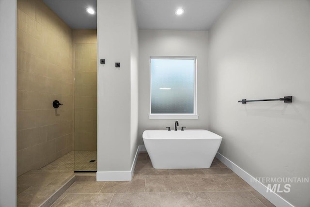 20042 N Swire Green Way Unit 459, Boise, ID 83714 - bathroom featuring a freestanding tub, baseboards, a tile shower, and tile patterned flooring