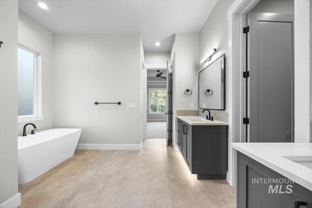 20042 N Swire Green Way Unit 459, Boise, ID 83714 - full bathroom with two vanities, a freestanding bath, recessed lighting, a ceiling fan, and baseboards