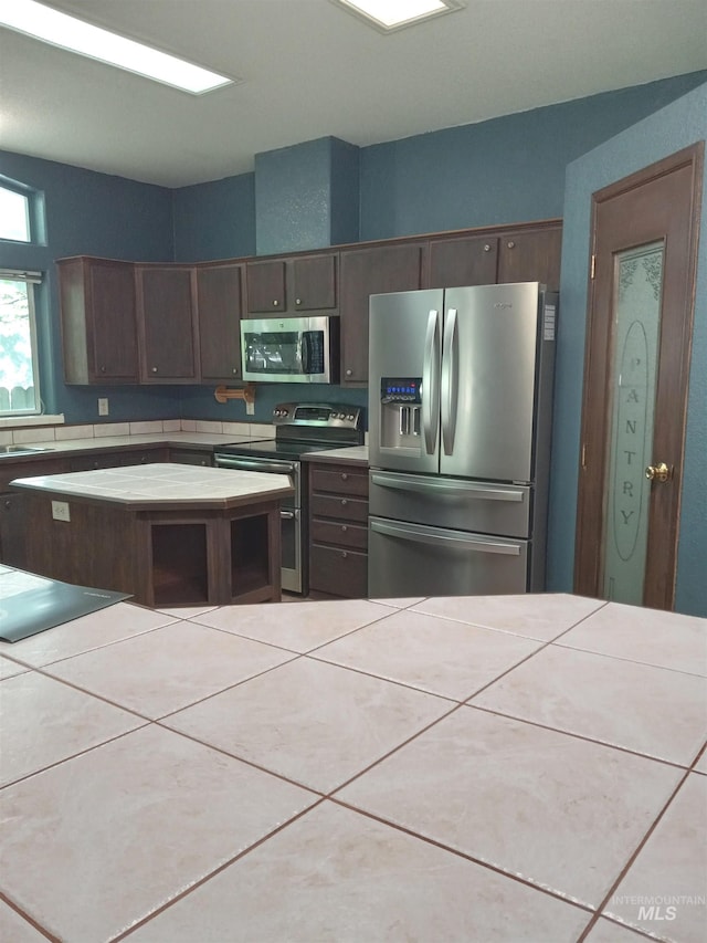 410 Cedar St, Middleton, ID 83644 - kitchen with stainless steel appliances, tile countertops, dark brown cabinets, a sink, and tile patterned floors