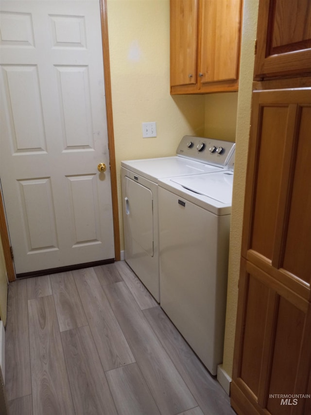 410 Cedar St, Middleton, ID 83644 - washroom featuring washer and clothes dryer, light wood-style flooring, and cabinet space