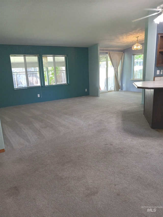 410 Cedar St, Middleton, ID 83644 - unfurnished living room featuring carpet, a chandelier, and ceiling fan