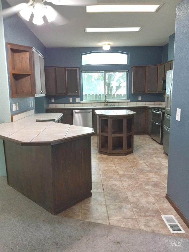 410 Cedar St, Middleton, ID 83644 - kitchen featuring open shelves, appliances with stainless steel finishes, a peninsula, dark brown cabinets, and tile counters