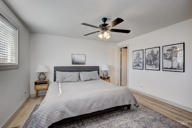 8561 W Goddard, Boise, ID 83704 - bedroom with baseboards, a textured ceiling, light wood-style floors, and ceiling fan