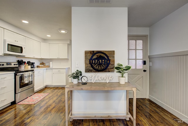 8561 W Goddard, Boise, ID 83704 - kitchen with white cabinetry, dark wood-style flooring, white microwave, and stainless steel electric range