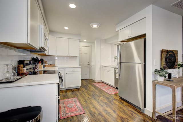 8561 W Goddard, Boise, ID 83704 - kitchen featuring dark wood-style floors, tasteful backsplash, white cabinets, and stainless steel appliances