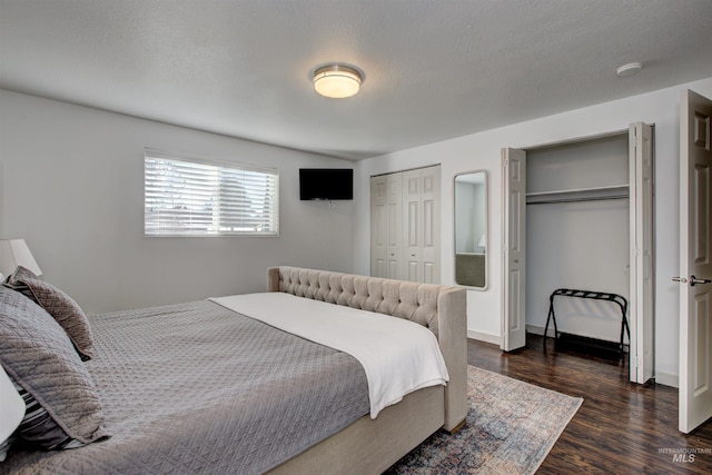 8561 W Goddard, Boise, ID 83704 - bedroom with dark wood-style floors, two closets, baseboards, and a textured ceiling