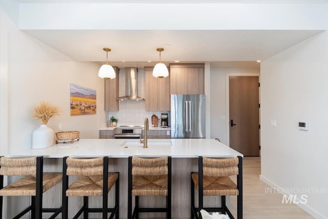 4184 E Haystack St Unit 206, Boise, ID 83716 - kitchen featuring wall chimney range hood, freestanding refrigerator, a sink, modern cabinets, and a breakfast bar area