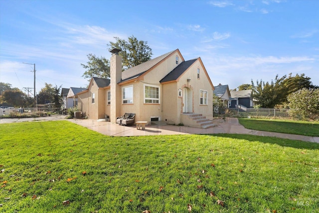 rear view of property featuring a lawn, a patio, and central air condition unit