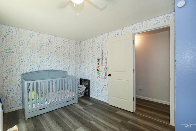 1765 W 6th St, Weiser, ID 83672 - bedroom featuring wallpapered walls, baseboards, wood finished floors, a crib, and a ceiling fan