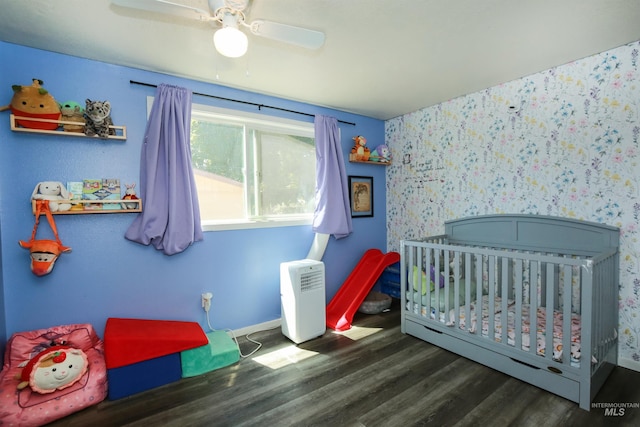1765 W 6th St, Weiser, ID 83672 - bedroom featuring wood finished floors, baseboards, a nursery area, wallpapered walls, and a ceiling fan