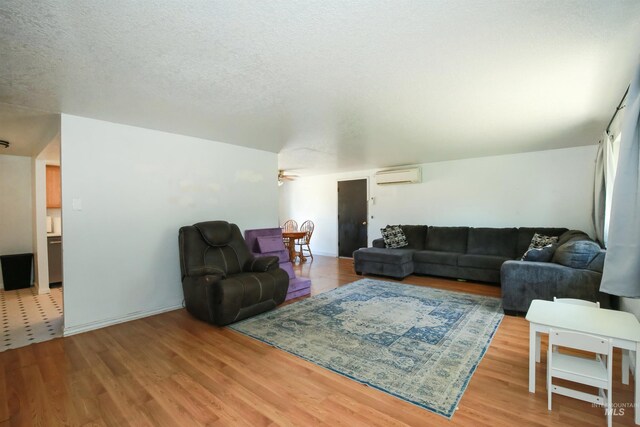 1765 W 6th St, Weiser, ID 83672 - living room featuring a wall mounted AC, wood finished floors, a textured ceiling, and ceiling fan