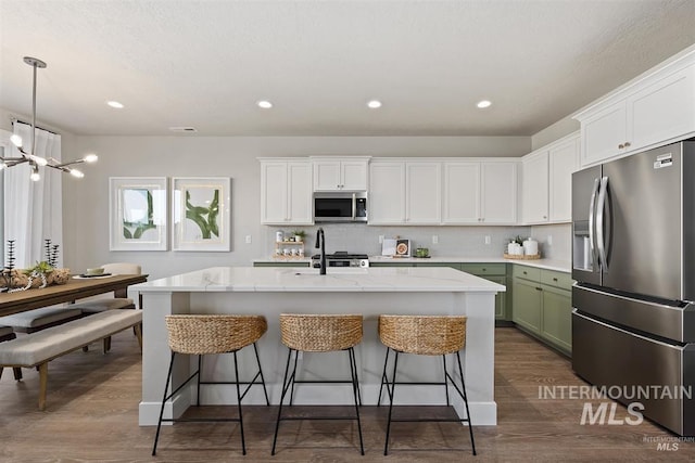 5591 W Aralia Dr, Meridian, ID 83646 - kitchen featuring appliances with stainless steel finishes, white cabinetry, and a breakfast bar