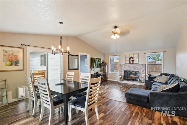 3118 Fircrest Ave, Caldwell, ID 83605 - dining space featuring dark wood-style floors, vaulted ceiling, a chandelier, a fireplace, and a ceiling fan