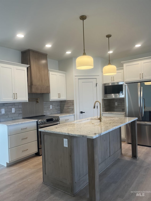 kitchen with stainless steel appliances, a sink, light wood-style flooring, and custom exhaust hood