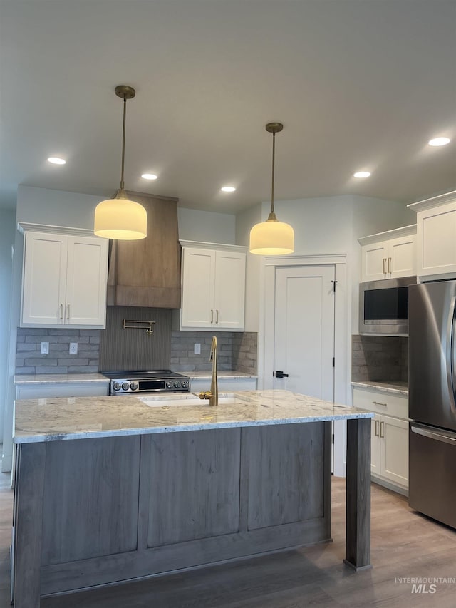 kitchen featuring stainless steel appliances, white cabinets, and backsplash