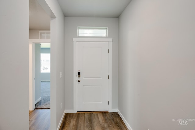 doorway to outside with dark wood-type flooring, visible vents, and baseboards