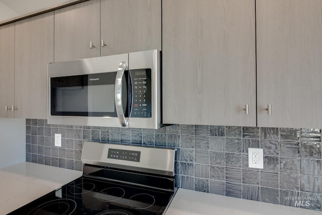 kitchen featuring modern cabinets, appliances with stainless steel finishes, light countertops, and backsplash