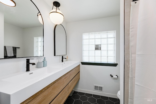 1706 Hervey, Boise, ID 83705 - bathroom with a sink, toilet, visible vents, tile patterned floors, and double vanity