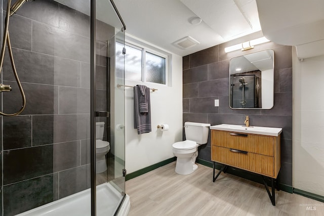1706 Hervey, Boise, ID 83705 - full bathroom with tile walls, toilet, visible vents, a shower stall, and wood finished floors