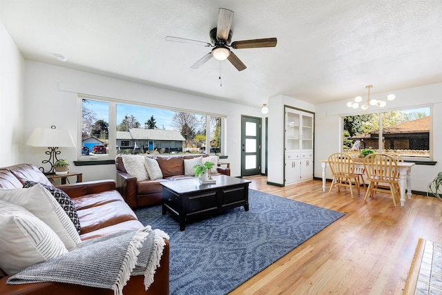 1706 Hervey, Boise, ID 83705 - living room with a wealth of natural light, light wood-style floors, and ceiling fan with notable chandelier