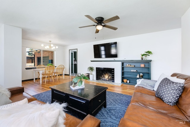 1706 Hervey, Boise, ID 83705 - living area featuring a tile fireplace, ceiling fan with notable chandelier, and wood finished floors