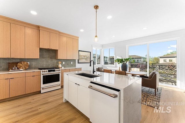 kitchen featuring white appliances, a sink, light wood-type flooring, backsplash, and hanging light fixtures