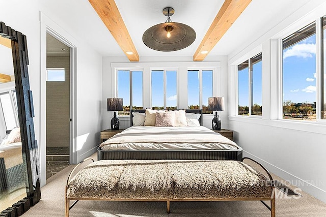 carpeted bedroom featuring baseboards and beamed ceiling