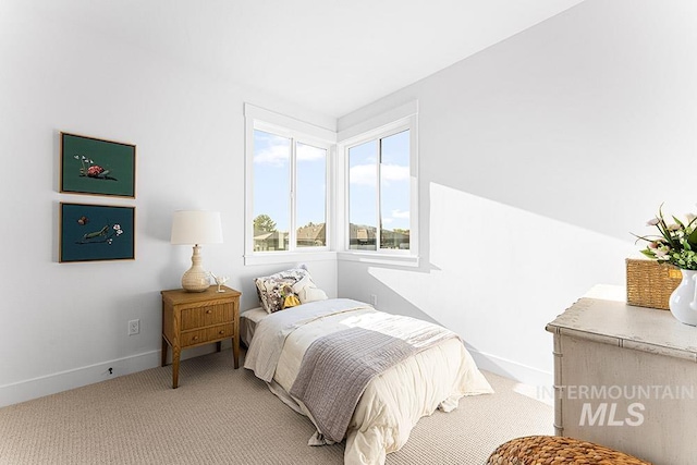 bedroom with light carpet and baseboards