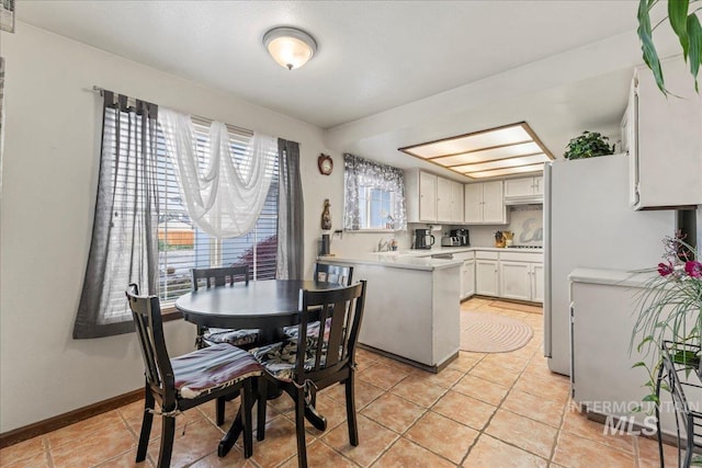 dining space featuring baseboards and light tile patterned floors