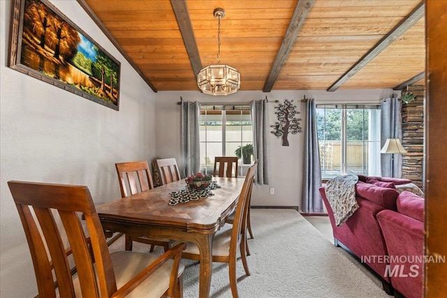 dining room with a notable chandelier, light colored carpet, a healthy amount of sunlight, and wood ceiling