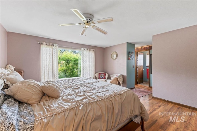 bedroom featuring a ceiling fan, baseboards, and light wood-style floors