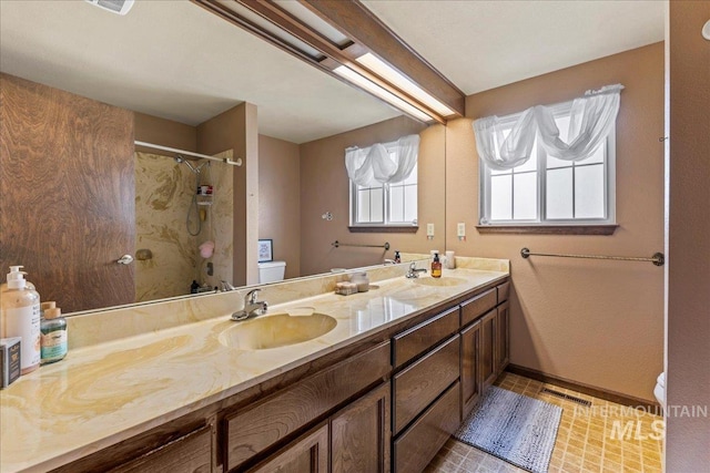 bathroom with toilet, walk in shower, a sink, and visible vents