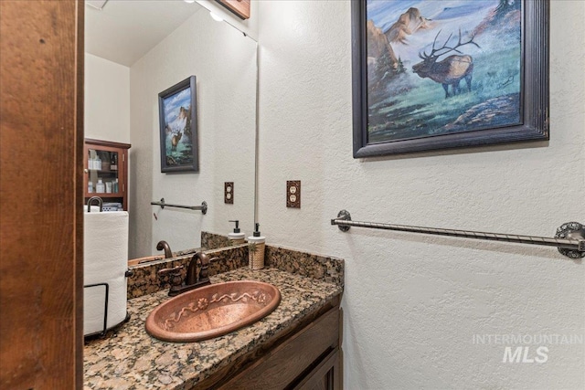 bathroom with vanity and a textured wall