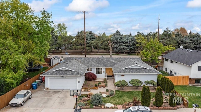 single story home with concrete driveway, fence, and a garage
