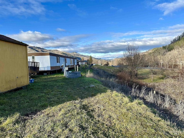 view of yard featuring a deck with mountain view