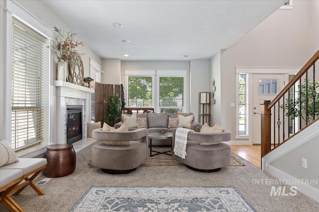 living room featuring a fireplace, a textured ceiling, and hardwood / wood-style flooring