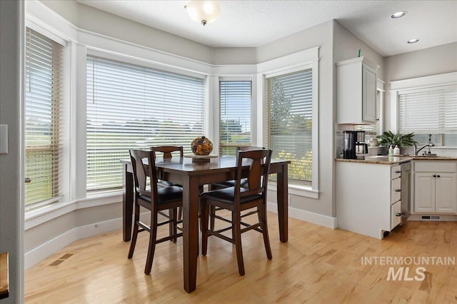 dining area with light hardwood / wood-style flooring and sink