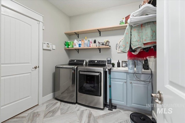 washroom featuring cabinets, independent washer and dryer, and a textured ceiling