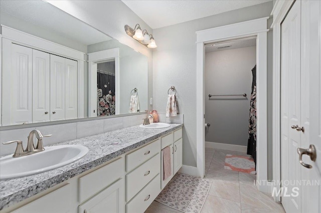 bathroom featuring tile patterned floors, vanity, and backsplash