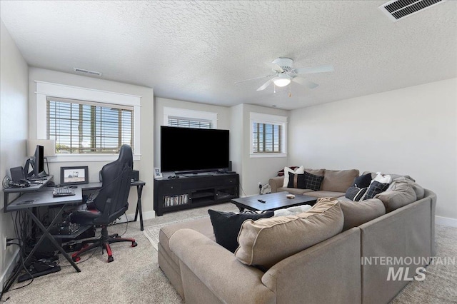 carpeted living room featuring a textured ceiling, a wealth of natural light, and ceiling fan