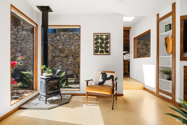 2036 N Blaine Way, Boise, ID 83702 - sitting room featuring a wood stove, tile patterned floors, and baseboards