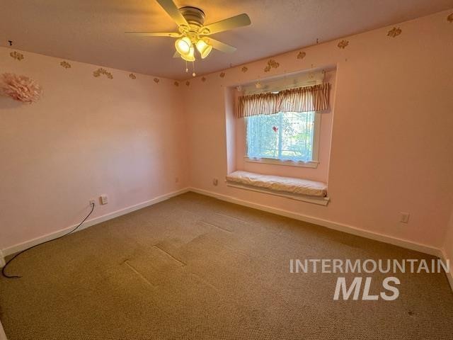 spare room with carpet floors and ceiling fan