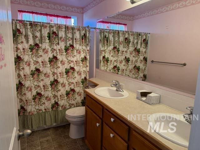 full bathroom featuring shower / bath combo, vanity, and toilet