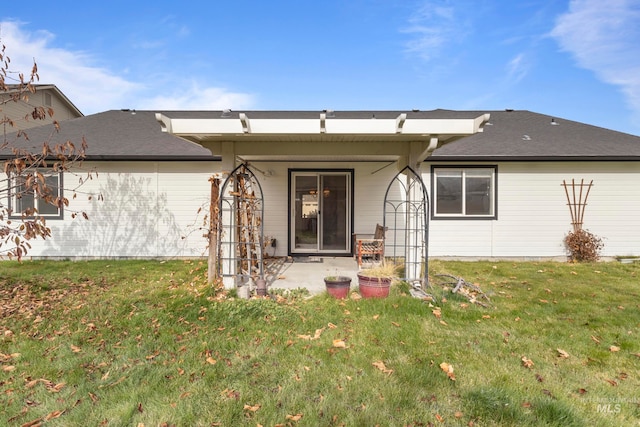 back of house featuring a patio and a lawn