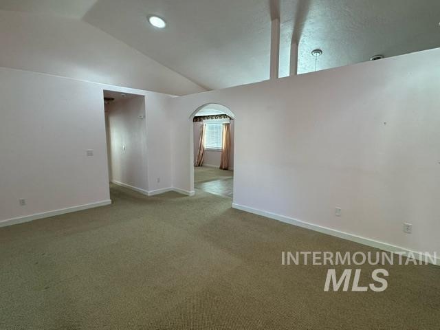 unfurnished room with carpet and lofted ceiling