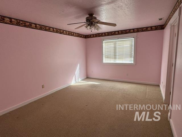 unfurnished room with a textured ceiling, light carpet, and ceiling fan