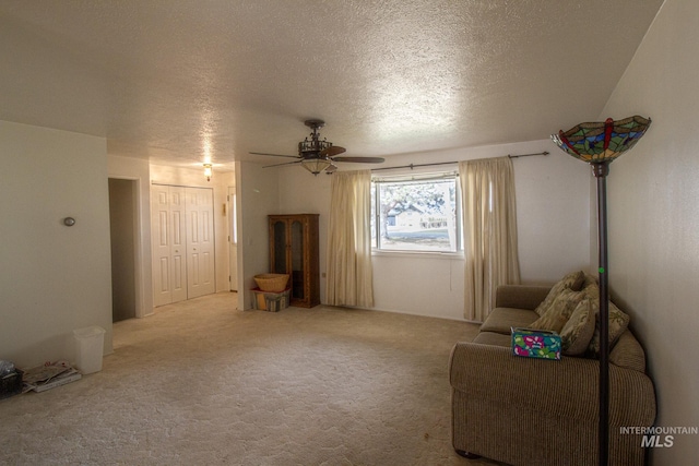 unfurnished room with ceiling fan, light colored carpet, and a textured ceiling