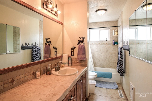 full bathroom with tile patterned flooring, a textured ceiling, toilet, shower / bath combo with shower curtain, and vanity