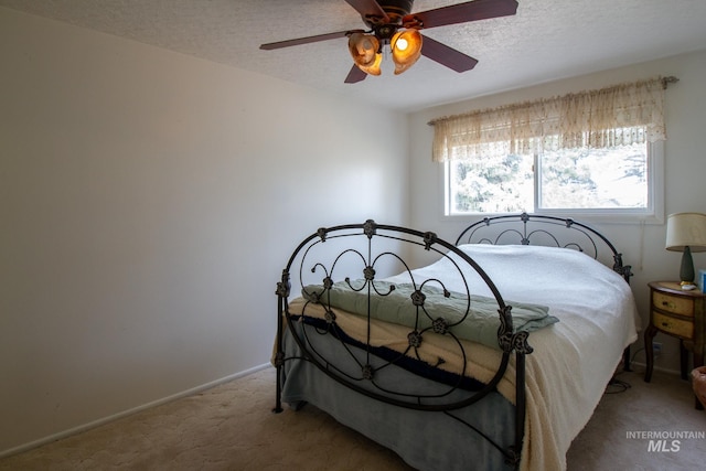 carpeted bedroom with ceiling fan and a textured ceiling